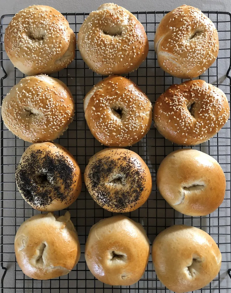 A tray of bagels cooling on a rack